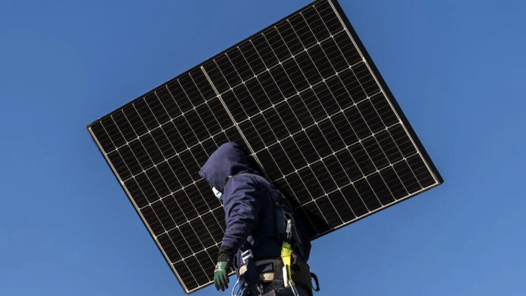 solar worker carrying solar panels-majeski solar energy
